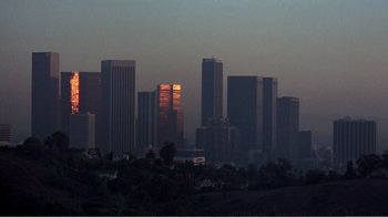 Movie still from “Repo Man” (1984), directed by Alex Cox – A view of a city skyline at dusk; Extreme Wide shot, High angle