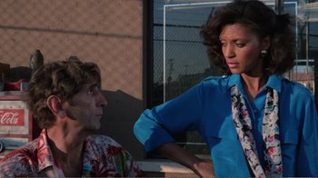 Movie still from “Repo Man” (1984), directed by Alex Cox – A man and a woman are talking outside; Medium shot, Over the shoulder angle