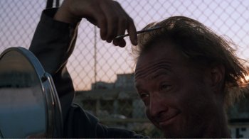 Movie still from “Repo Man” (1984), directed by Alex Cox – A person cutting his own hair; Close Up shot, Low angle