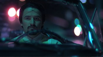 Movie still from “Repo Man” (1984), directed by Alex Cox – A man with a bandage on his head looking out of a car window; Close Up shot, Low angle