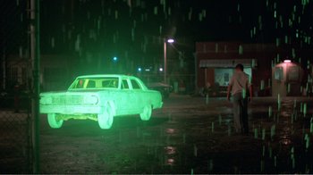 Movie still from “Repo Man” (1984), directed by Alex Cox – A car that is lit up in the rain; Wide shot, Low angle