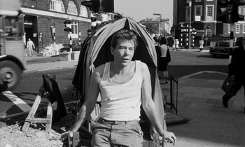 Movie still from “Repulsion” (1965), directed by Roman Polanski – A black and white photo of a man with a umbrella; Medium shot, Low angle