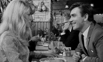 Movie still from “Repulsion” (1965), directed by Roman Polanski – A man and a woman sitting at a table; Medium shot, Over the shoulder angle
