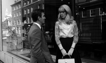 Movie still from “Repulsion” (1965), directed by Roman Polanski – A man and a woman standing next to each other on the sidewalk; Medium shot, Low angle