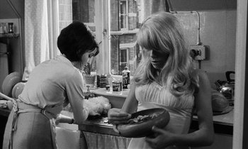 Movie still from “Repulsion” (1965), directed by Roman Polanski – Two women are sitting at a table and one of the women is holding a plate; Medium shot, High angle