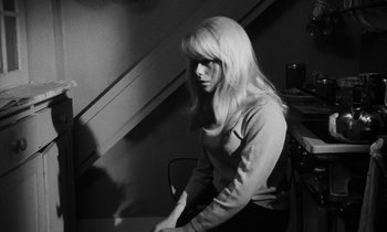 Movie still from “Repulsion” (1965), directed by Roman Polanski – A woman sitting on a chair in front of a staircase; Medium shot, High angle