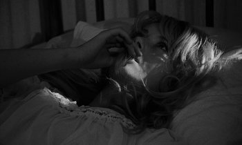 Movie still from “Repulsion” (1965), directed by Roman Polanski – A woman laying in a bed with her eyes closed; Close Up shot, High angle
