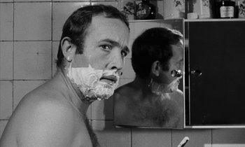 Movie still from “Repulsion” (1965), directed by Roman Polanski – A black and white photo of a man shaving in a mirror; Close Up shot, Over the shoulder angle