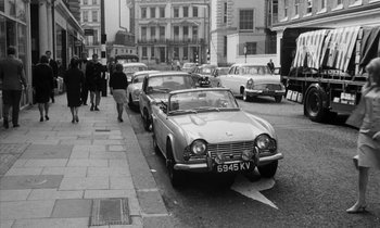 Movie still from “Repulsion” (1965), directed by Roman Polanski – An old photo of cars parked on the side of the street; Wide shot, High angle