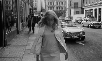 Movie still from “Repulsion” (1965), directed by Roman Polanski – A black and white photo of a woman walking down the street; Medium shot, Low angle