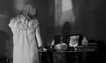 Movie still from “Repulsion” (1965), directed by Roman Polanski – A woman standing in front of a desk with a laptop; Medium shot, Over the shoulder angle