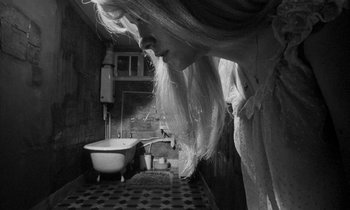 Movie still from “Repulsion” (1965), directed by Roman Polanski – A black and white photo of a woman looking into a bathroom; Close Up shot, Low angle