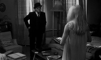 Movie still from “Repulsion” (1965), directed by Roman Polanski – A man and a woman are standing in front of a mirror; Medium shot, Over the shoulder angle