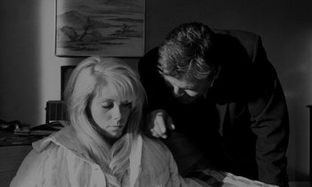 Movie still from “Repulsion” (1965), directed by Roman Polanski – A man and a woman sitting on a bed; Medium shot, Over the shoulder angle