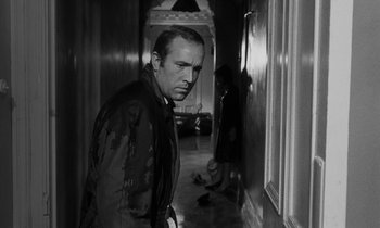 Movie still from “Repulsion” (1965), directed by Roman Polanski – A black and white photo of a man and a woman in a hallway; Medium shot, Over the shoulder angle