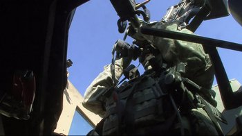 Movie still from “Restrepo” (2010), directed by Tim Hetherington – A person in military gear is standing in a vehicle; Close Up shot, Low angle