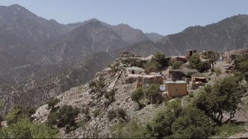 Movie still from “Restrepo” (2010), directed by Tim Hetherington – A view of a mountainous area with a lot of trees; Extreme Wide shot, Low angle