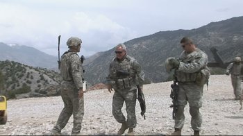 Movie still from “Restrepo” (2010), directed by Tim Hetherington – A group of men standing on top of a hill; Wide shot, Over the shoulder angle