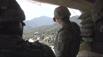 Movie still from “Restrepo” (2010), directed by Tim Hetherington – A soldier in a military uniform looking out of a helicopter window; Wide shot, Low angle