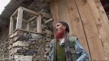 Movie still from “Restrepo” (2010), directed by Tim Hetherington – An old man with a beard and a red beard; Medium shot, Low angle