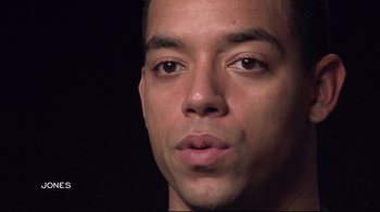 Movie still from “Restrepo” (2010), directed by Tim Hetherington – A man's face in a dark room; Close Up shot, Low angle