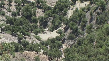 Movie still from “Restrepo” (2010), directed by Tim Hetherington – An aerial view of trees in a hilly area; Extreme Wide shot, High angle