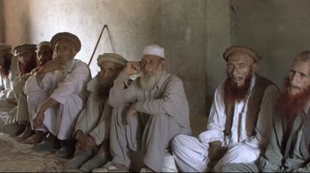 Movie still from “Restrepo” (2010), directed by Tim Hetherington – A group of men sitting next to each other; Wide shot, High angle