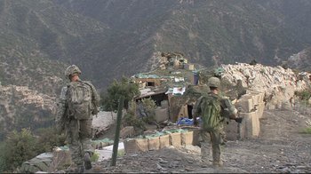 Movie still from “Restrepo” (2010), directed by Tim Hetherington – A group of men standing on top of a hill; Extreme Wide shot, Over the shoulder angle