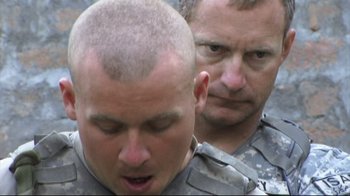Movie still from “Restrepo” (2010), directed by Tim Hetherington – Two men in military fatigues looking at each other; Close Up shot, Over the shoulder angle