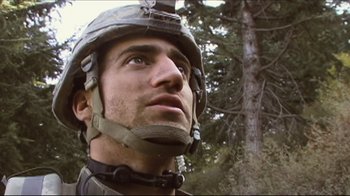 Movie still from “Restrepo” (2010), directed by Tim Hetherington – A man wearing a helmet looking into the distance; Close Up shot, Low angle