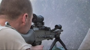 Movie still from “Restrepo” (2010), directed by Tim Hetherington – A man is looking through a rifle scope; Extreme Close Up shot, High angle