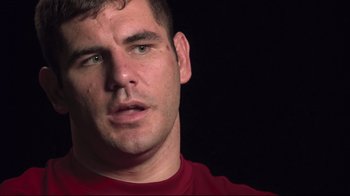 Movie still from “Restrepo” (2010), directed by Tim Hetherington – A person wearing a red shirt; Close Up shot, Low angle