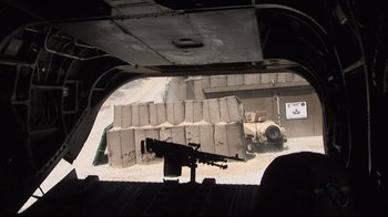 Movie still from “Restrepo” (2010), directed by Tim Hetherington – A view from inside an airplane of a military vehicle; Wide shot, High angle