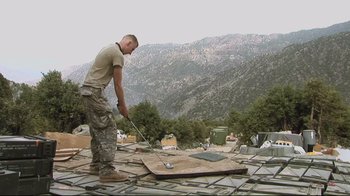 Movie still from “Restrepo” (2010), directed by Tim Hetherington – A man standing on top of a building; Wide shot, Low angle