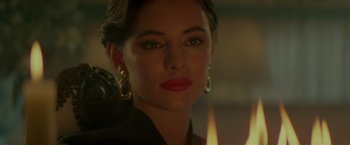 Movie still from “Revenge” (1990), directed by Tony Scott – A person with a candle in the background; Close Up shot, Over the shoulder angle