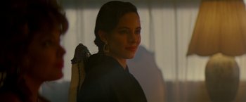 Movie still from “Revenge” (1990), directed by Tony Scott – A beautiful young lady wearing a black jacket; Close Up shot, Over the shoulder angle