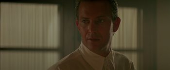 Movie still from “Revenge” (1990), directed by Tony Scott – A person wearing a shirt and tie; Close Up shot, Low angle