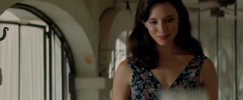 Movie still from “Revenge” (1990), directed by Tony Scott – A beautiful woman in a floral dress standing in a room; Close Up shot, Over the shoulder angle