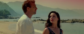 Movie still from “Revenge” (1990), directed by Tony Scott – A man and a woman standing next to each other on the beach; Close Up shot, Low angle