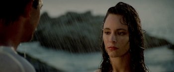 Movie still from “Revenge” (1990), directed by Tony Scott – A woman standing in the pouring rain with her eyes closed; Close Up shot, Over the shoulder angle