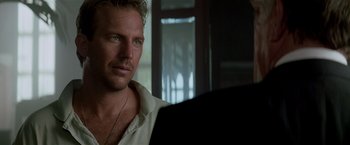 Movie still from “Revenge” (1990), directed by Tony Scott – A person wearing a white shirt; Close Up shot, Over the shoulder angle
