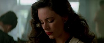 Movie still from “Revenge” (1990), directed by Tony Scott – A person wearing a white shirt and red lipstick; Close Up shot, Low angle