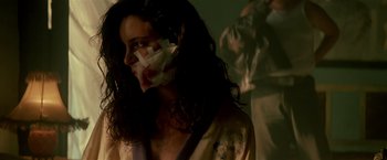 Movie still from “Revenge” (1990), directed by Tony Scott – A woman with bandages around her mouth and face; Close Up shot, Low angle