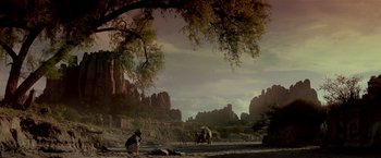 Movie still from “Revenge” (1990), directed by Tony Scott – An image of a man and a horse in the desert; Extreme Wide shot, Low angle