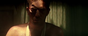 Movie still from “Revenge” (1990), directed by Tony Scott – A person with a bandage on his face; Close Up shot, Low angle