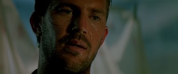 Movie still from “Revenge” (1990), directed by Tony Scott – A person with sweat on his face; Close Up shot, Low angle