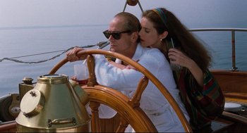 Movie still from “Reversal of Fortune” (1990), directed by Barbet Schroeder – A man and a woman on a boat steering; Medium shot, Low angle