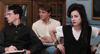 Movie still from “Reversal of Fortune” (1990), directed by Barbet Schroeder – A man and two women sitting next to each other in a room; Medium shot, Over the shoulder angle