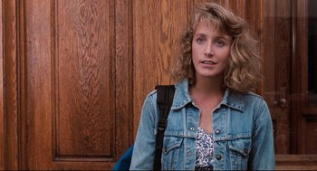 Movie still from “Reversal of Fortune” (1990), directed by Barbet Schroeder – A woman with curly blonde hair wearing a jean jacket; Close Up shot, Over the shoulder angle