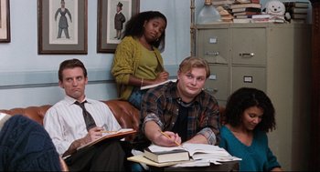 Movie still from “Reversal of Fortune” (1990), directed by Barbet Schroeder – A group of people sitting at a table with papers; Medium shot, High angle